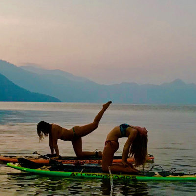 two girls yoga practice SUP