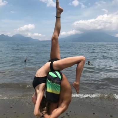 partners yoga practice on beach